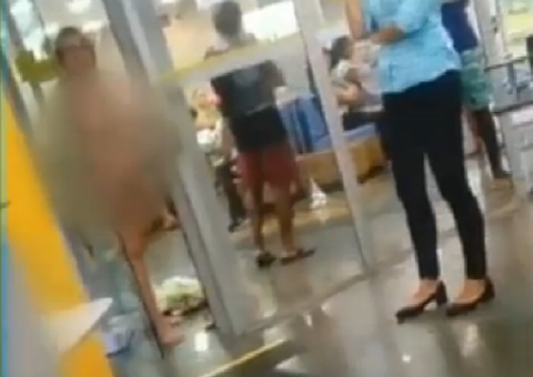 Mulher fica nua após ser barrada em porta giratória de banco