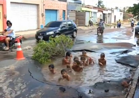 Buraco abre na rua e vira piscina para crianças