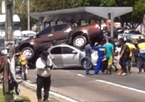 Mitsubishi 'surfa' em cima de outro carro em frente ao Sesi